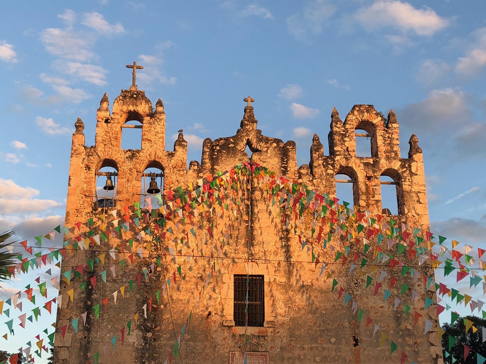 Colorful bunting on a historic mission church at sunset