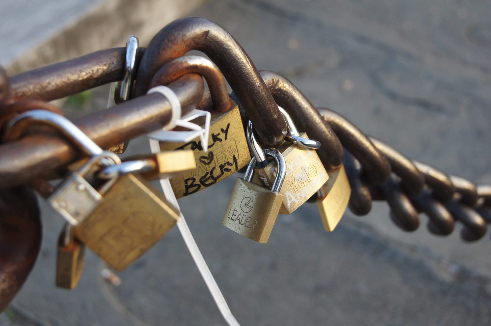Padlocks engraved with names on a bridge railing