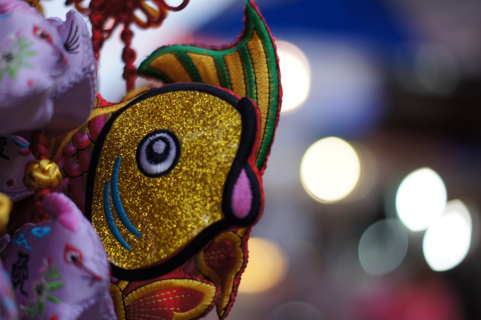 Gold embroidered fish ornament with bokeh lights